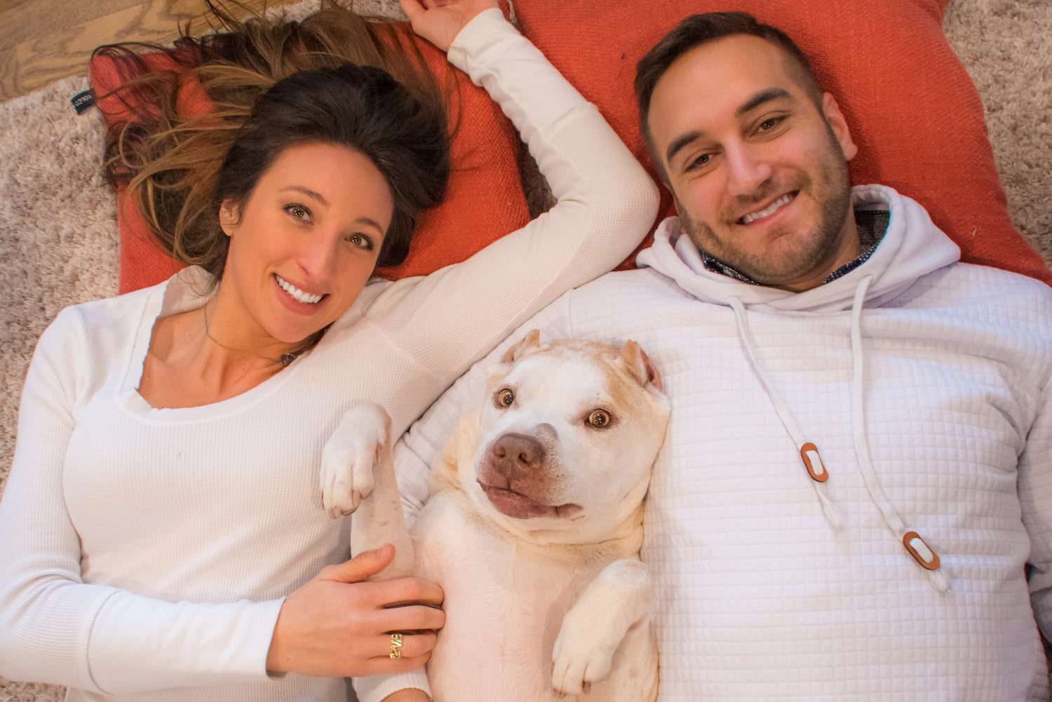 Jason and Michelina smile and cuddle with Bubbins, who is also smiling